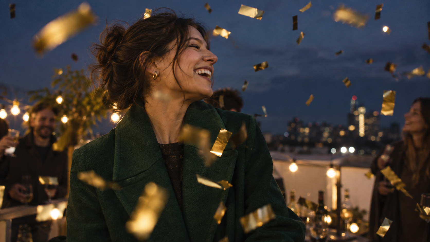 Sparse gold confetti crossing a rooftop portrait against dark dusk sky