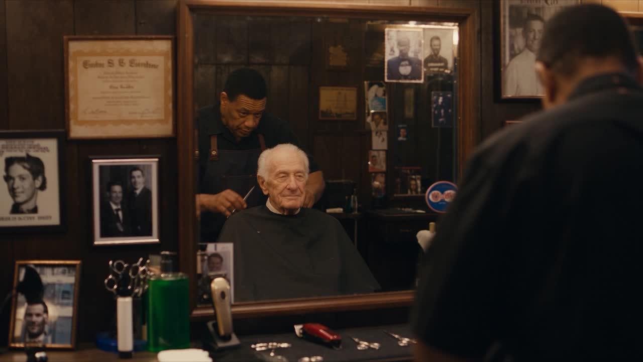 A cinematic barbershop scene with an elderly customer reflected in a mirror and the barber working behind him